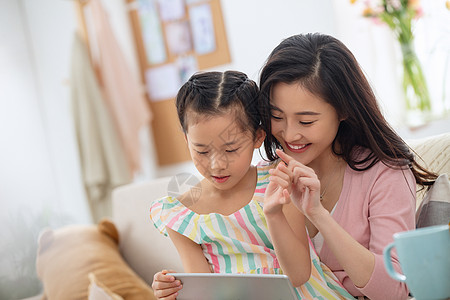 东亚青年人摄影快乐母女在家看平板电脑图片