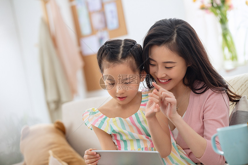 东亚青年人摄影快乐母女在家看平板电脑图片