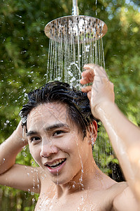 人自来水纯洁年轻男人在户外淋浴洗头图片