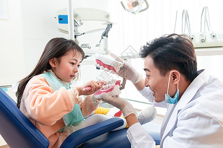 小孩刷牙水平构图牙科诊疗室医院可爱的小女孩和牙科医生背景