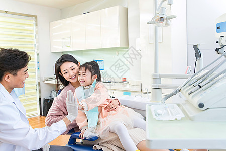 年轻妈妈带着小女孩看牙医高清图片