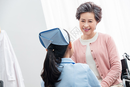 病房成年人微笑护士和老年人交谈图片