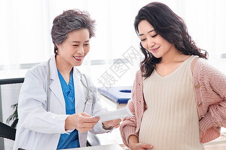 快乐工作专门技术白昼微笑医生给孕妇检查身体背景