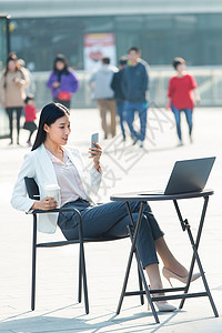 跷二郎腿城市生活餐厅二郎腿青年商务女士在户外工作背景