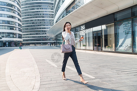 商业区望京soho着装得体拿着咖啡的商务女打电话高清图片