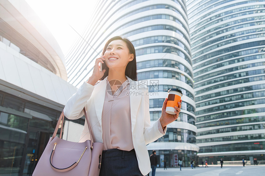 金融区拿着咖啡的商务女打电话图片