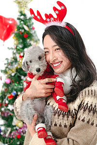 抱着宠物狗的青年女人过圣诞节图片