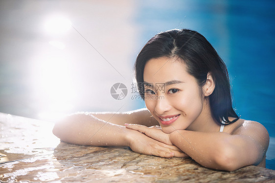 穿着泳衣在游泳池里的青年女人图片