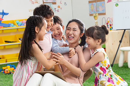 老师和孩子做游戏上课可爱的幼儿园老师和小朋友们拥抱在一起背景