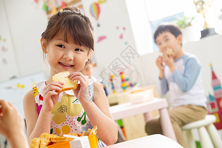 幼儿园小朋友用餐吃三明治高清图片