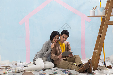 倚靠亚洲人欢乐年轻夫妇装修房子图片