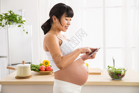 女性腹部身体关注东方人东亚孕妇看平板电脑背景
