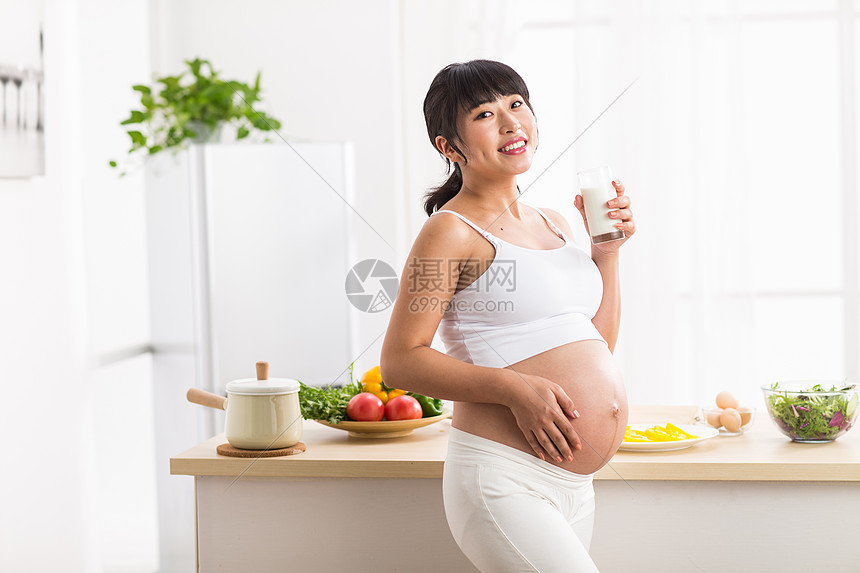 手放在肚子上孕妇喝牛奶图片