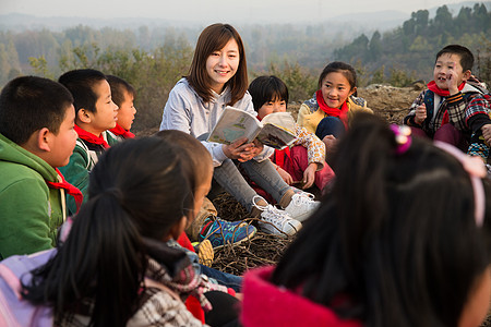 一群女生乡村教师和小学生在户外学习背景