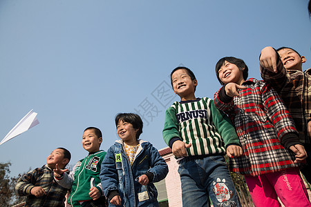 乐观表现积极玩耍乡村小学生在学校放纸飞机图片
