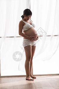 青年女人垂直构图观察幸福的孕妇图片