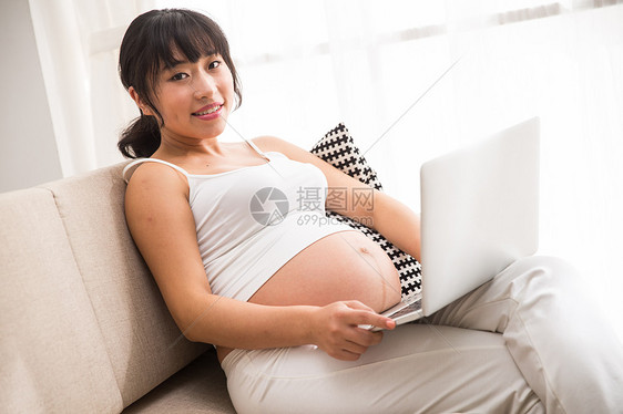 快乐20到24岁住宅房间孕妇使用电脑图片