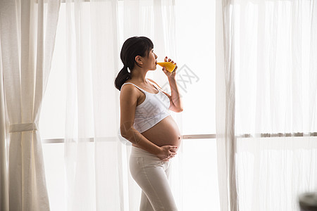 20到24岁户内健康的孕妇喝果汁图片