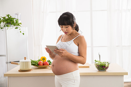 通讯仅女人期待孕妇看平板电脑高清图片