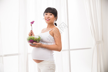 水平构图简单身体保养幸福的孕妇吃蔬菜沙拉图片