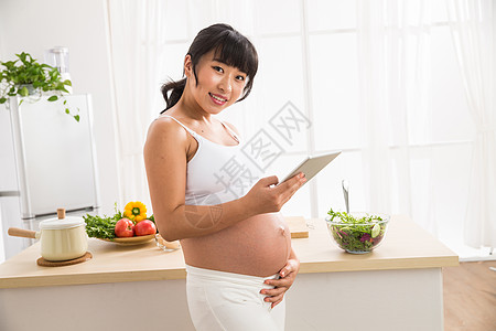 放松仅女人新生活孕妇看平板电脑图片