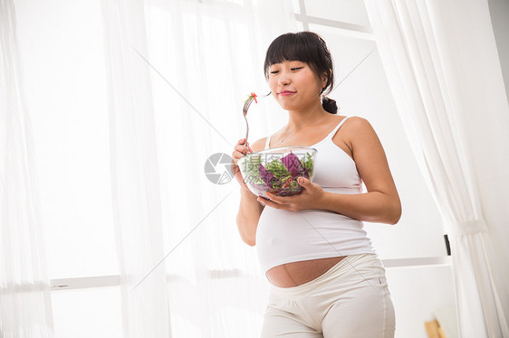 母亲青年人仅一个人幸福的孕妇吃蔬菜沙拉图片