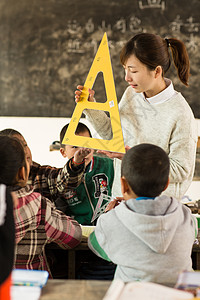 待遇可爱的乡村女教师和小学生在教室里高清图片