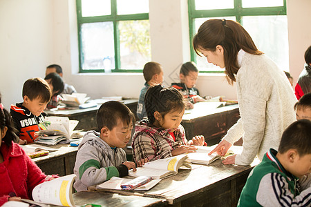 学生在上课友谊人希望小学乡村女教师和小学生在教室里背景