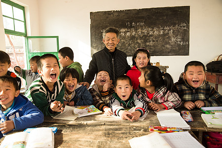 相伴乐观愉悦乡村男教师和小学生在教室里图片