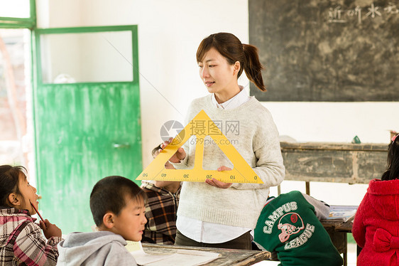 天真学习微笑的乡村女教师和小学生在教室里图片