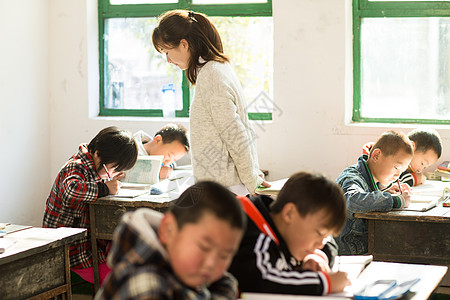 男孩和女孩童年社会问题表现积极乡村女教师和小学生在教室里背景