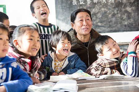 微笑的户内课桌乡村女教师和小学生在教室里图片