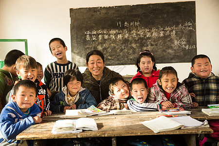 团结少量人群相伴乡村女教师和小学生在教室里图片