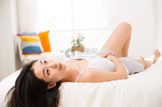东方人可爱的享乐青年女人在卧室的床上图片