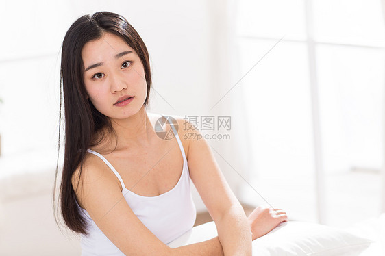 窗户水平构图情绪压力青年女人坐在床上图片