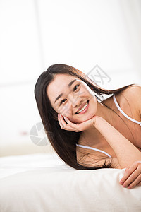 住房独处欢乐青年女人在卧室的床上图片
