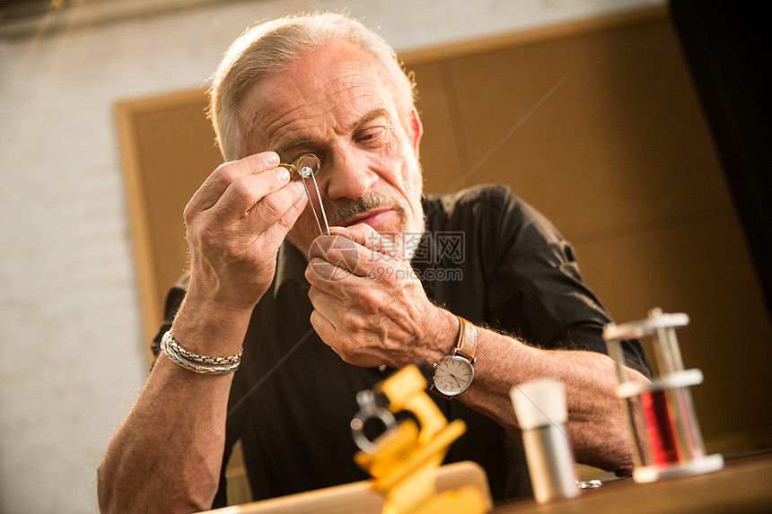美术工艺珠宝店工匠老年男人制作钻石戒指