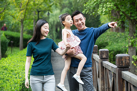 一家三口愉悦幸福家庭在户外散步图片