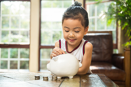 小孩存钱罐理财小女孩把钱放入存钱罐背景