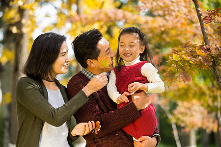 孕妇和小孩高兴的休闲装毛衣幸福家庭在户外玩耍背景