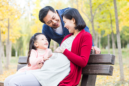 孕妇和小孩坐着休闲装核心家庭幸福家庭在户外玩耍背景