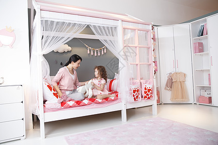 人家庭床可爱的小女孩和妈妈在卧室玩耍图片