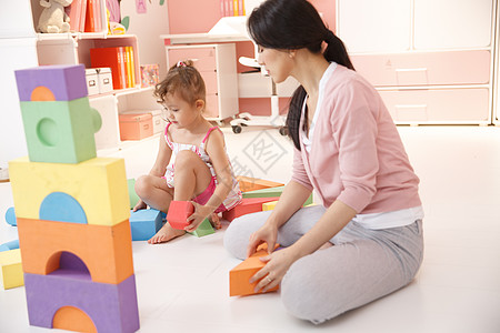 装饰物3岁到4岁柔和可爱的小女孩和妈妈在卧室玩耍高清图片