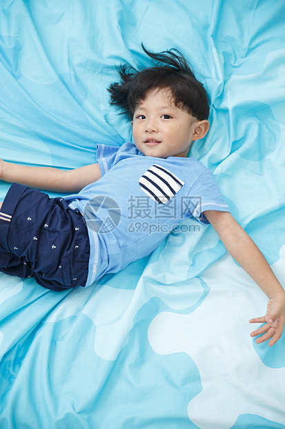 家庭生活东方人4岁到5岁可爱的小男孩在床上玩耍图片