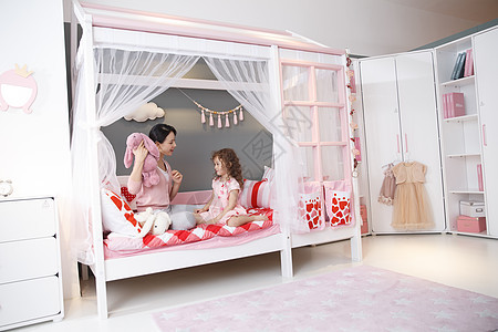 游戏相伴女儿可爱的小女孩和妈妈在卧室玩耍图片