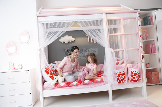 纯洁白种人家可爱的小女孩和妈妈在卧室玩耍图片