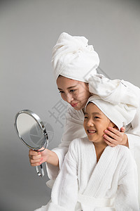 温馨快乐户内穿着浴袍的母女照镜子图片