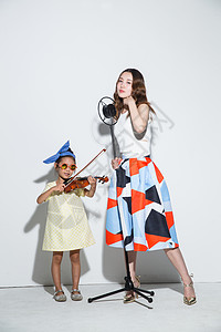 天真有趣的东方人小女孩和妈妈拉小提琴图片