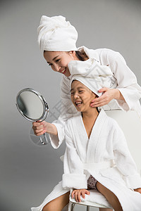 20多岁温馨母亲穿着浴袍的母女照镜子图片