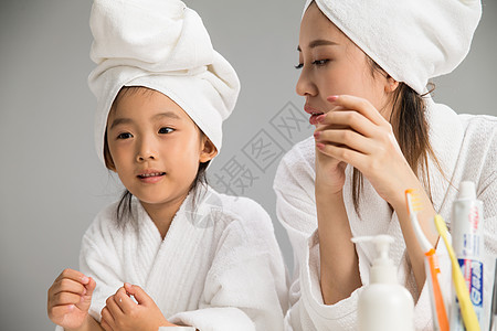 东方人身体保健浴室穿着浴袍的母女图片